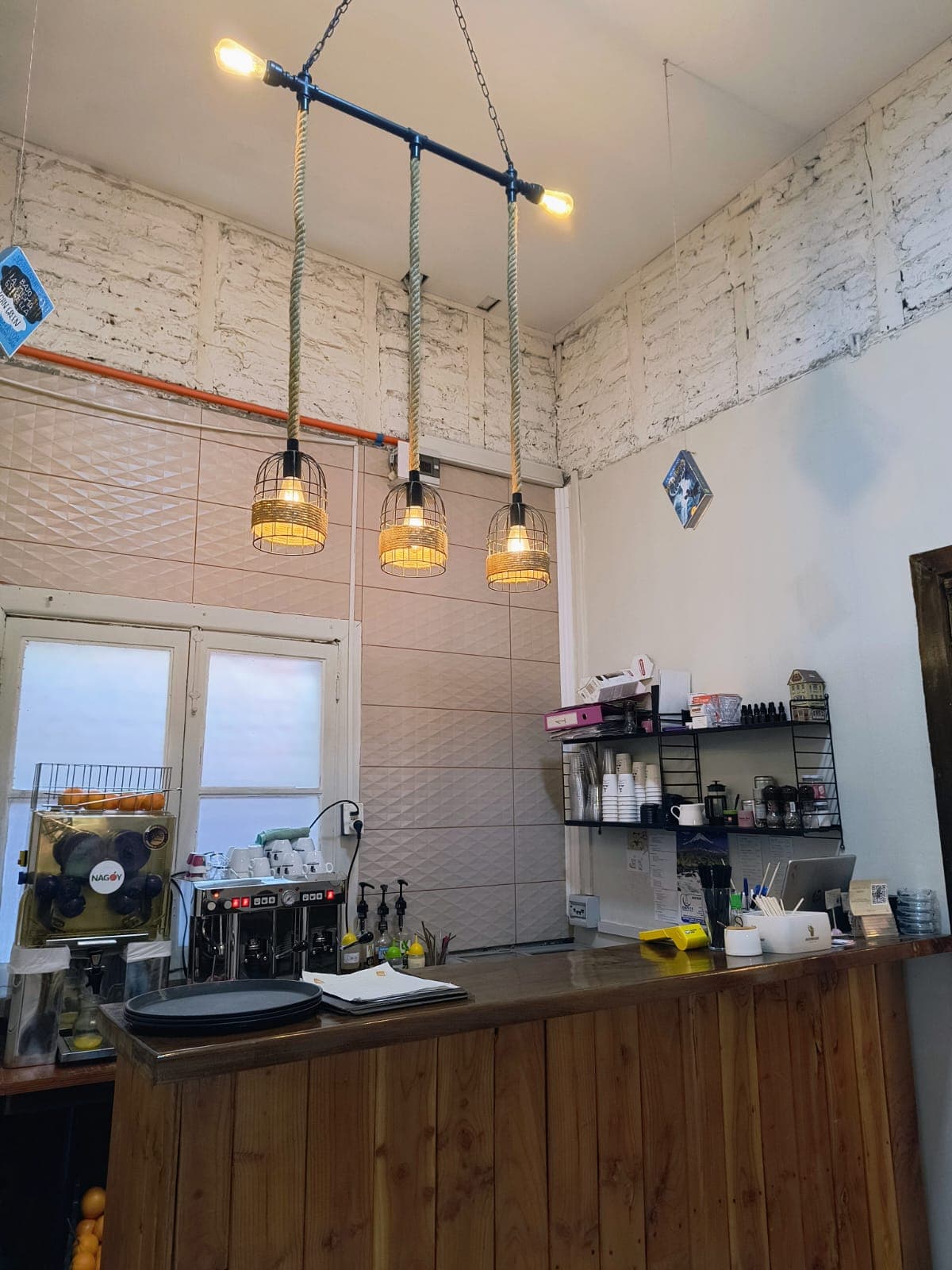 La barra de café bajo lámparas de cuerda y muros de ladrillo blanco